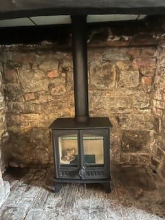 Hunter Herald 5 Eco double door stove installed in a stone fireplace setting.