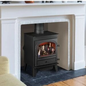 Black wood-burning stove with a glass front, set within a white fireplace mantel and hearth.