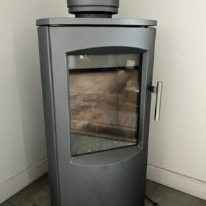 Modern gray wood stove with a glass front and a metal chimney pipe attached on top.