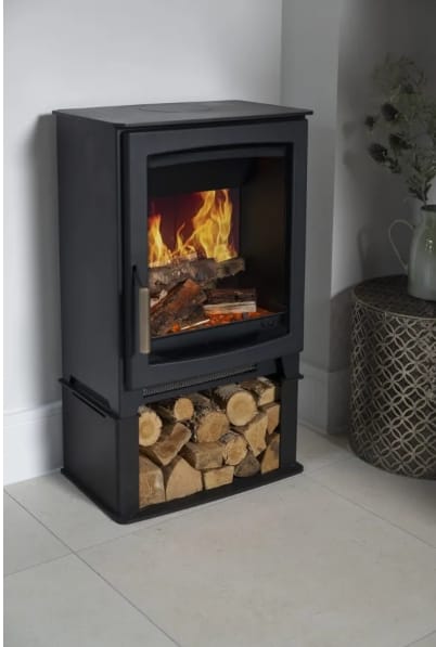 A black Parkray Aspect 5 Pure Flame Electric Stove with realistic flames and a log storage base stands against a light wall in a modern room.