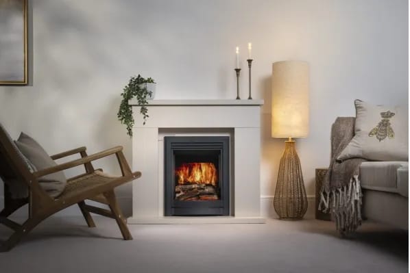 Parkray Inset Pure Flame LCD electric fire glows within a white mantel, with realistic flames and a dark inset finish in a calm living room setting.